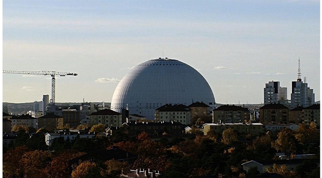 En stadsbild av Stockholm med den vita, sfäriska byggnaden Ericsson Globe, ett känt landmärke.